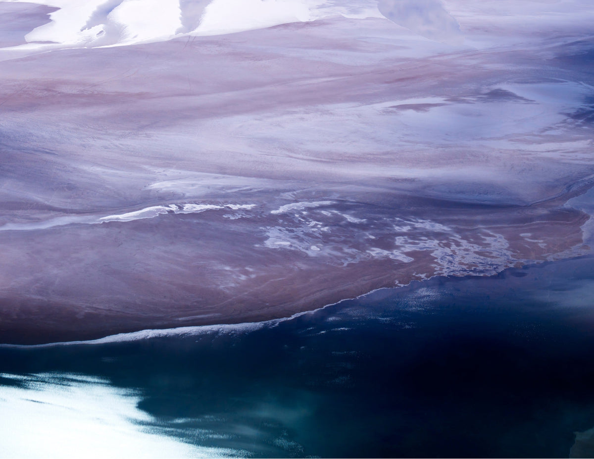 Aerial image of Coral Bay, Western Australia, where the pale sands of the Pilbara meet the deep indigo of the Indian Ocean at the edge of Ningaloo Reef.