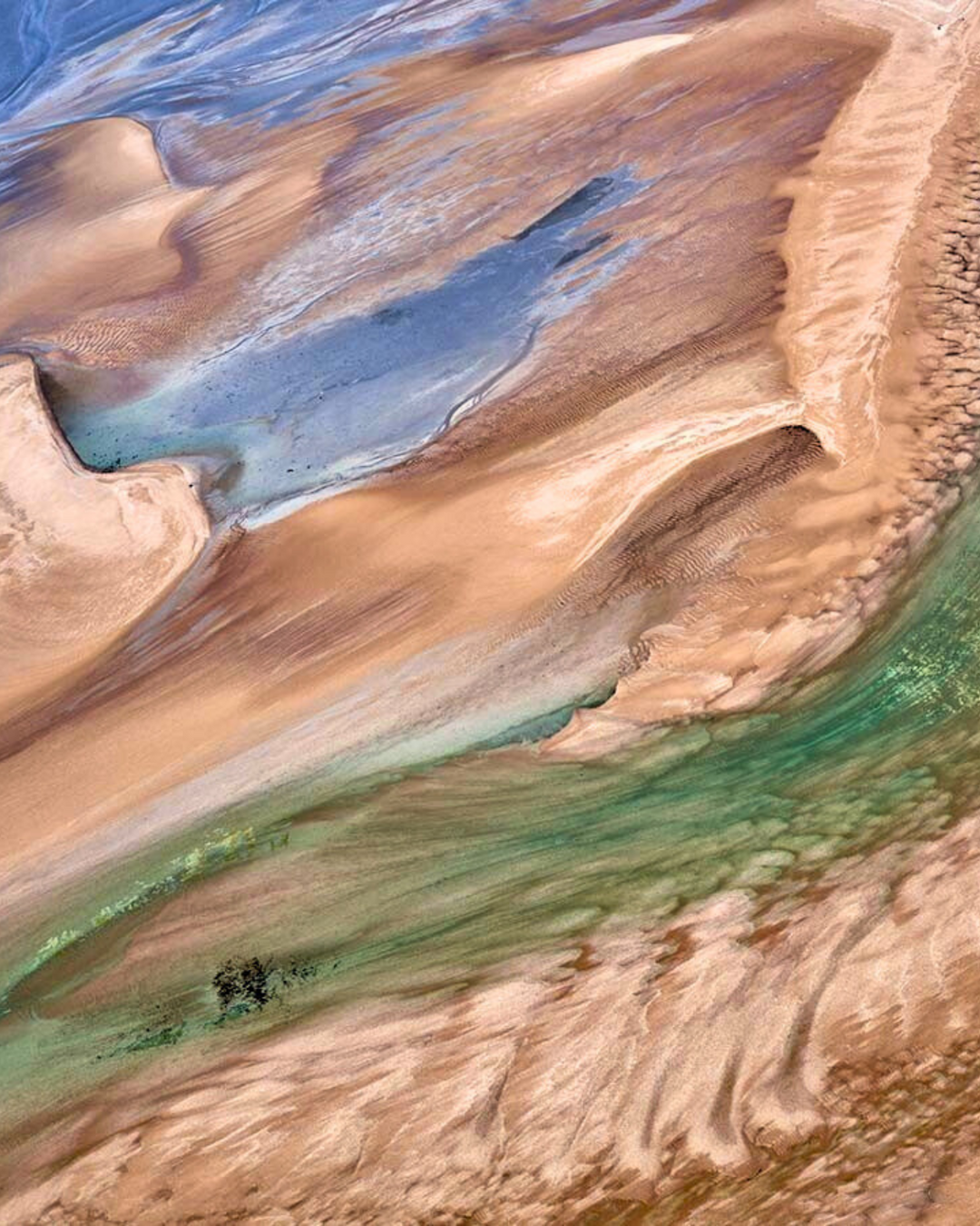 A stunning aerial image of an Eighty Mile Beach landscape in Western Australia – showing an amazing montage of sand dunes, green vegetation and blue water.