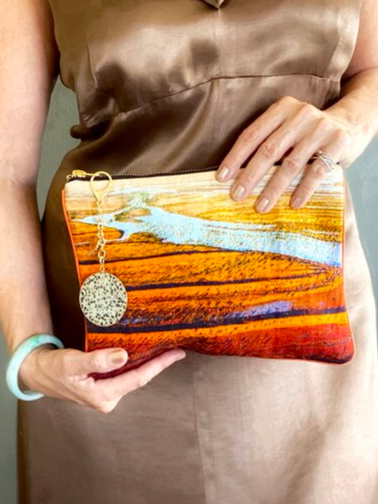 Our model accessorising an Australian landscape with the Simpson Desert clutch bag.